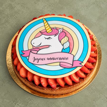Impression alimentaire personnalisée licorne « Joyeux anniversaire » sur tarte aux fraises – pâtisserie Déli Bo à Nice